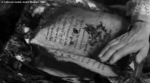 Photogramme - Livre : Andreï Roublev, Plan 267.   Une main feuillette les pages calcinées, c'est la main de la mort, la main de Théophane le Grec.