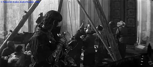 Andreï Roublev, plan 228c.  Les tatars devant l’église. Les envahisseurs défoncent avec un bélier en bois la porte de l'église. Au premier plan, la tête du cheval noir.