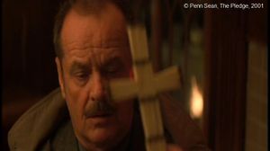   The Pledge  de Sean Penn.  Photogramme - 9.  0h 18’ 06’’. En retrouvant ses esprits, la mère de la victime présente une croix en allumettes que sa fille avait fabriquée, elle présente la croix devant Jerry, et elle lui fait promettre, sur la croix, de retrouver l’assassin cruel de sa petite fille.