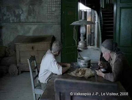 Le Visiteur, photogramme 30, plan 68, l'Enfant ne mange pas, il regarde fixement dans la direction de la porte. La Mère comprend l'embarras de l'Enfant. Et, enfin, nous l'entendons dire : « Il va habiter là un moment ».