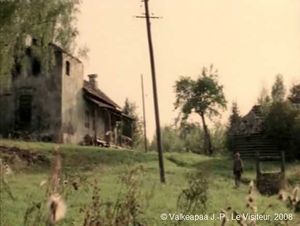 Le Visiteur, (Muukalainen), photogramme 7, plan 14b, l'Enfant pieds nus, arrive devant sa maison. Nous distinguons le puits et la maison.