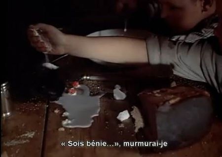Photogramme - Lait 2, Miroir (Le) (Zerkalo), Plan 17. Plan rapproché sur un chat noir qui lape du lait renversé sur une table de cuisine, en présence des deux petits enfants. Aliocha verse sur le chat noir une poudre blanche.