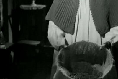  Viridiana de Luis Buñuel.     Photogramme 34 - Plan 31b. Viridiana vide la corbeille de cendre sur la couverture près des fleurs d'orangers.