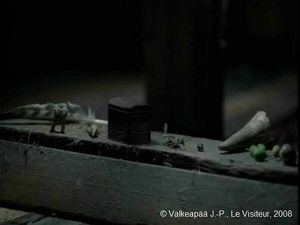 Le Visiteur, (Muukalainen), photogramme - plan 18, l'Enfant sort le mystérieux « coffre » et le dispose parmi une collection d'autres objets, aussi mystérieux que le coffre.
