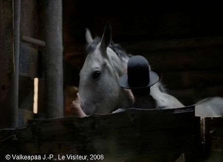 Le Visiteur, photogramme 64, plan 216, l'Enfant est surpris de voir le Visiteur, le chapeau sur la tête, en train de parler au cheval blanc. L'Enfant a l'air contrarié, il se retourne de l'autre côté et continue de dormir.